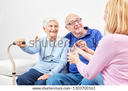 Smiling senior is taking tablet with water in senior home or at home