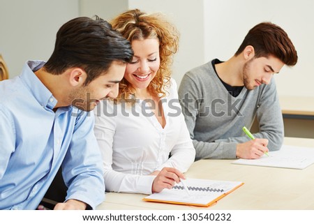 Woman explaining student exercises in university class