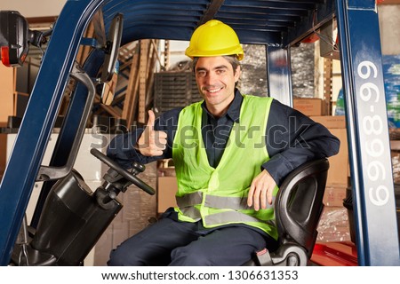Young warehouse worker with thumbs up as a stacker driver in a warehouse
