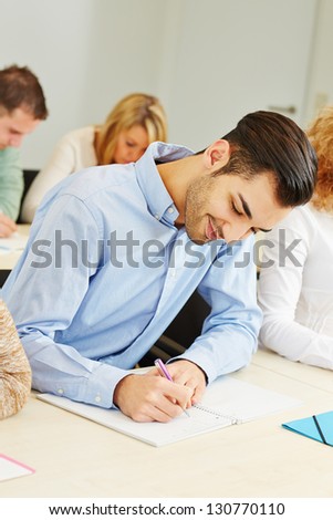 Student studying in course in university and taking notes