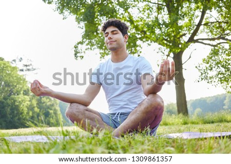 Young man makes breathing yoga exercise and meditates