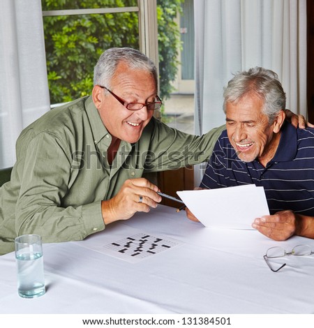 Two happy senior citizens solving riddles in a rest home