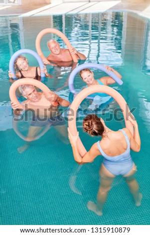 Senior group in aqua fitness with swimming noodle