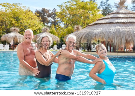 Senior group has fun with aqua fitness in the swimming pool of the hotel