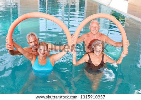 Seniors do exercises with swimming noodle in the aqua gym course