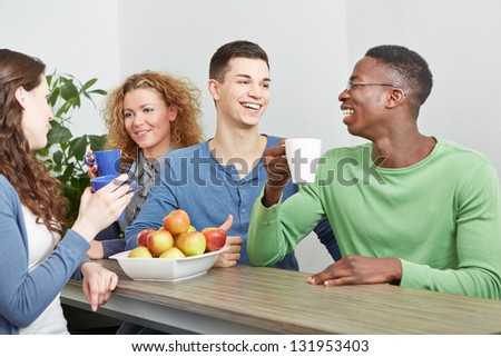 Many smiling colleagues drinking coffee in break room