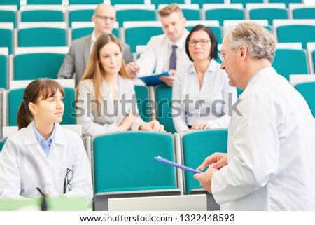 Young woman as medicine student in exam with professor