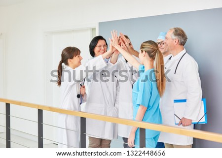 Clinic team of doctors share High Five for success motivation