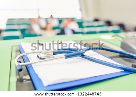 Stethoscope and clipboard on speaker desk in medicine training lecture