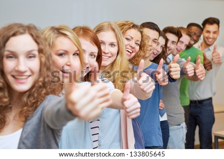 Happy students in a row holding their thumbs up