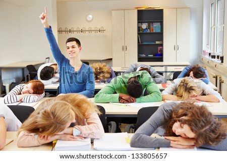 Sleeping students and diligent pupil in a school classroom