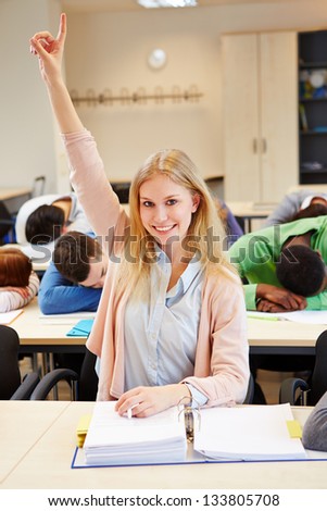 Diligent student raising her hand in a sleeping class
