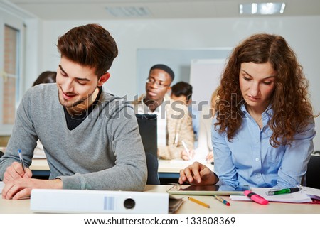 Young woman in university class learning with a tablet computer