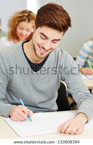 Young mann taking exam in university class