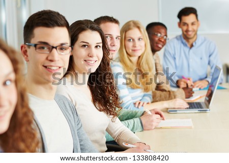 Class of many smiling students in a university Class of many smiling students in a university