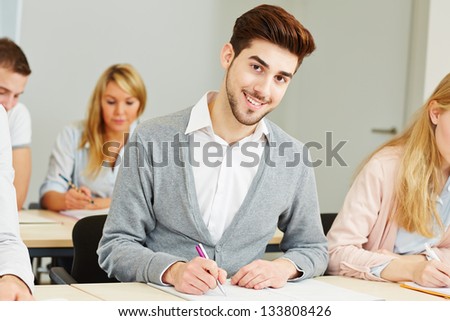 Happy young student learning for exam in school class