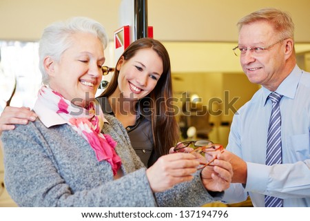 Elderly woman buying glasses with her grandchild at the optician
