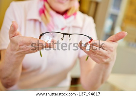 Hands of optician offering new fashionable glasses