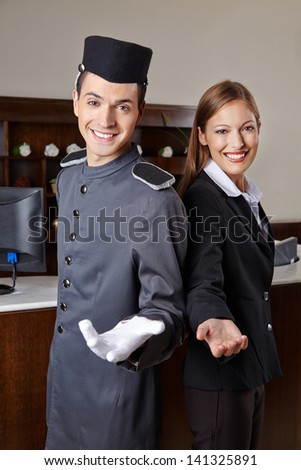Concierge and receptionist in hotel offering welcome to guests