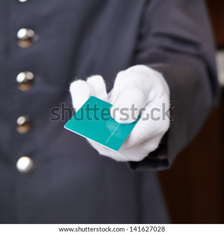 Hand of doorman giving key card to hotel room