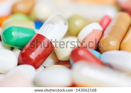Red pill within many colorful medicine and medication