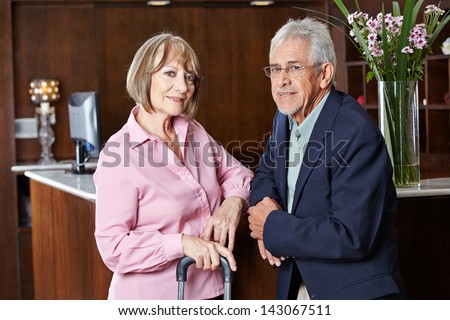Senior couple waiting at hotel reception for check-in