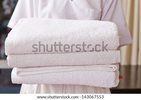 Maid in hotel with fresh towels on her arm