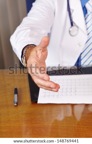 Doctor giving welcome handshake in his office