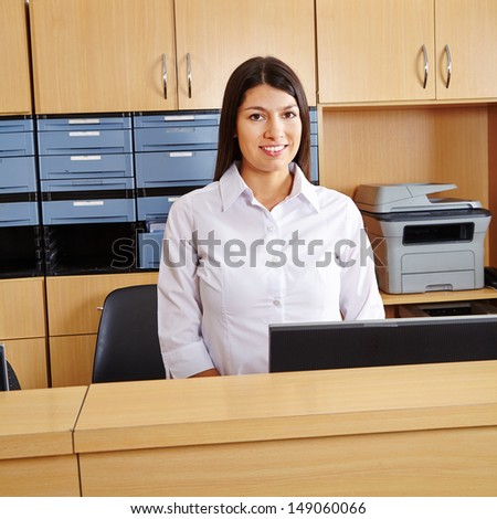 Smiling happy woman workingt at reception in a hospital