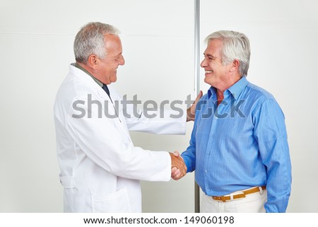 Doctor and senior patient giving welcome handshake in a hospital