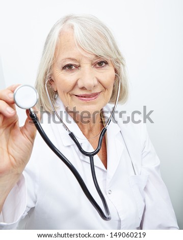 Elderly doctor with stethoscope in her hand