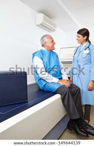 Doctor talking to senior patient before a bone density measurement