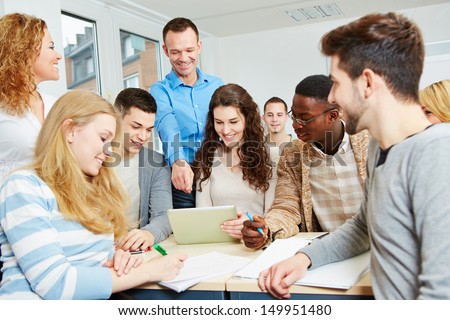 Happy students learning with teacher in university class