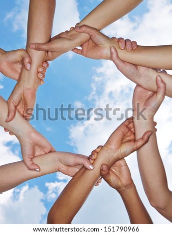 Group of many hands forming a chain under a sky