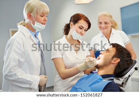 Dental assistant taking approbation test with two dentists