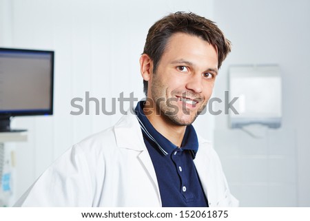 Portrait of a happy dentist in a white lab coat in dental practice