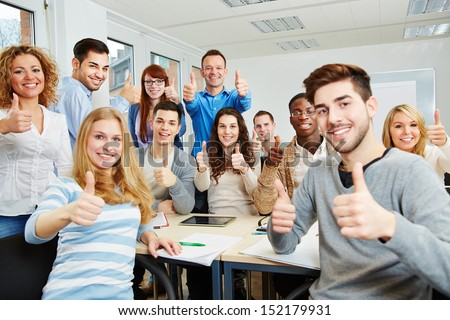 Many Happy Students With Teacher Holding Their Thumbs Up In University
