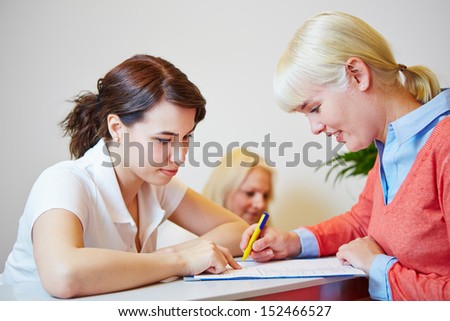 Female patient at physician filling out form for the appointment