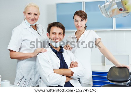 Happy dentist with his dental team in his dental practice