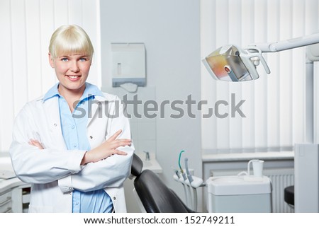 Smiling female dentist standing with her arms crossed in a dental practice