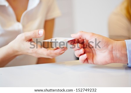 Hand of a patient giving smart card to doctors assistant