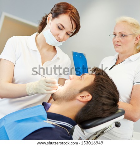 Prospective female dentist taking dental test with patient