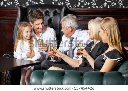 Happy family at wedding reception drinking glass of sparkling wine