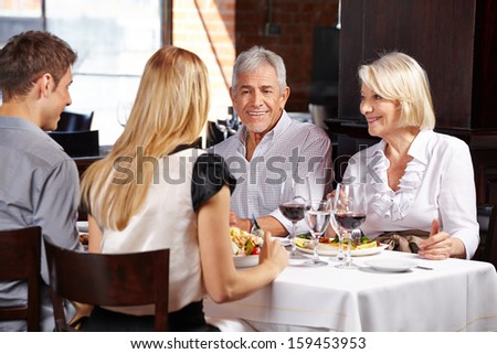 Couple With Family Eating Out In A Restaurant And Talking