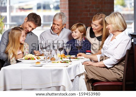 Happy family with children and seniors eating out in a restaurant