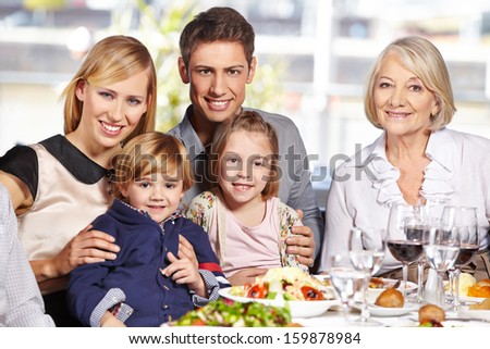 Happy family with children and grandmother sitting at lunch table