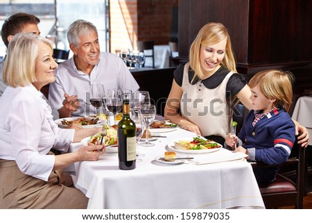 Family with child and grandparents eating out in a restaurant