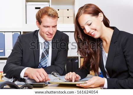 Two business people working with tablet computer at the desk in the office
