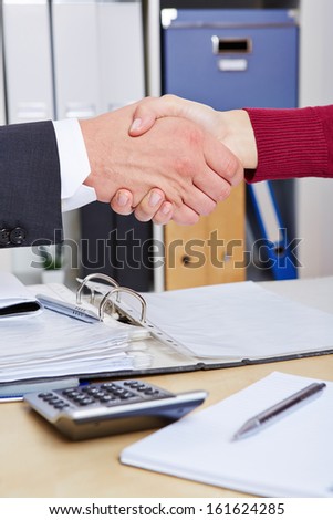Two business people doing a handshake in the office after a consultation