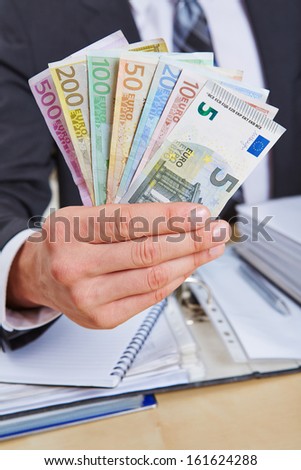 Manager in the office offering different Euro money bills